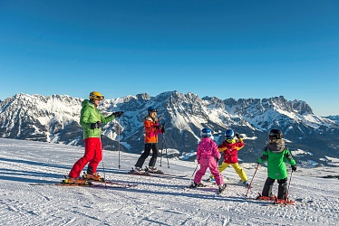 Familie beim Skifahren mit Panoramablick